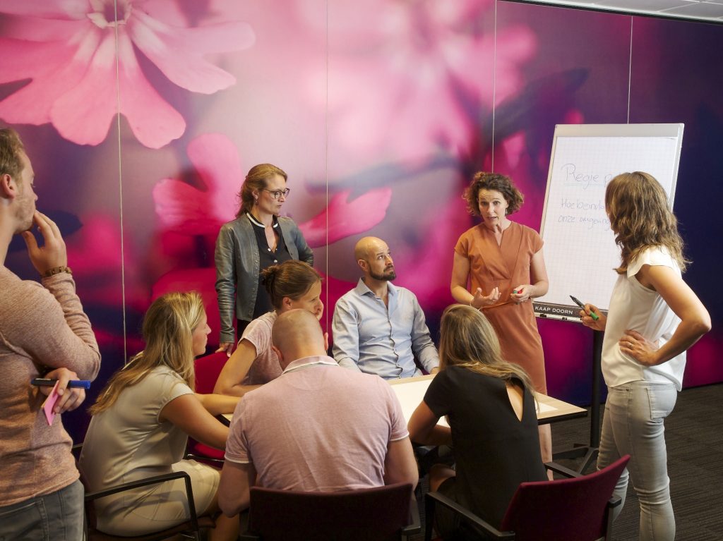 Deelnemers van de Deep Democracy-training in gesprek rond een tafel
