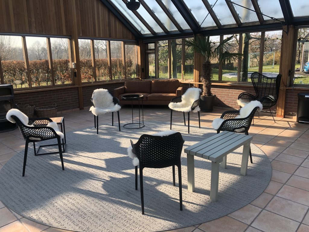 Kring stoelen met schapenvachten in het Glazenhuis in Langbroek