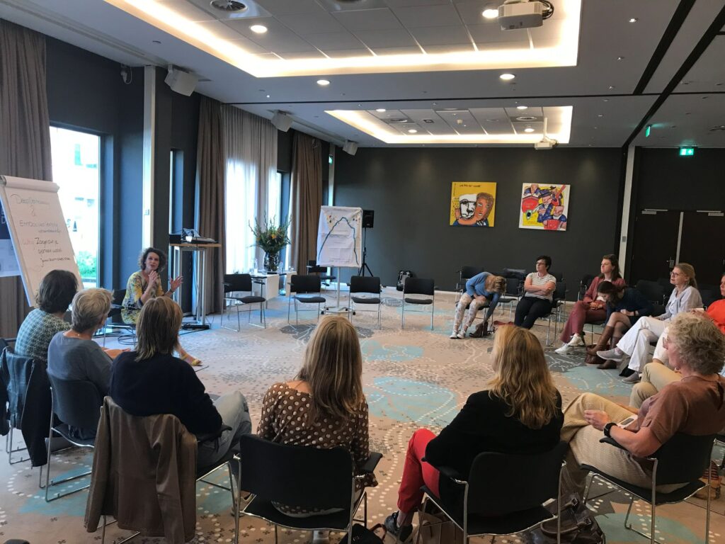 Deelnemers in een kring tijdens een Deep Democracy-sessie in company