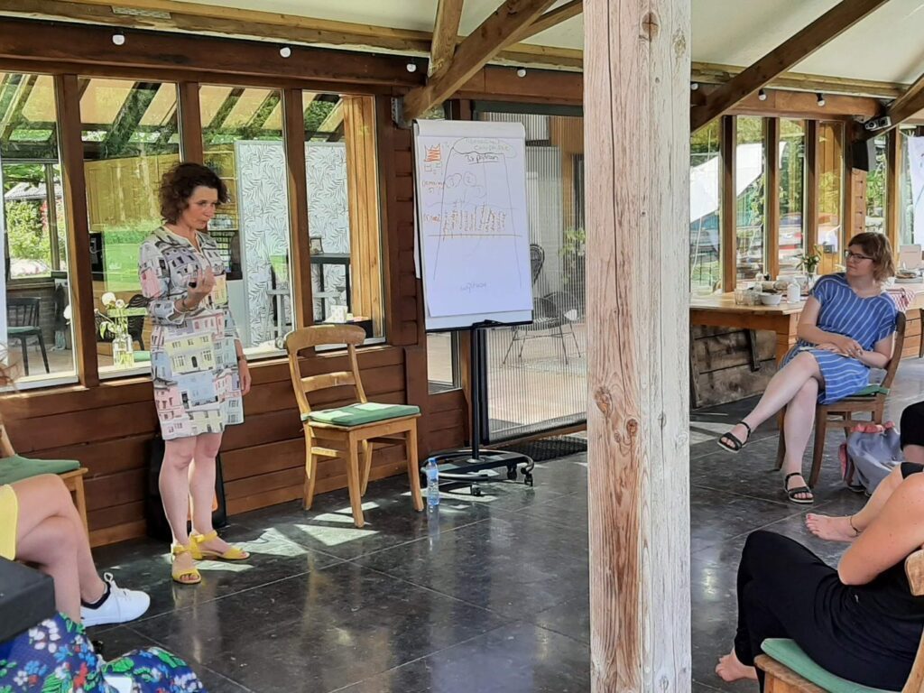 Inge Smak begeleidt een sessie onder de overkapping buiten