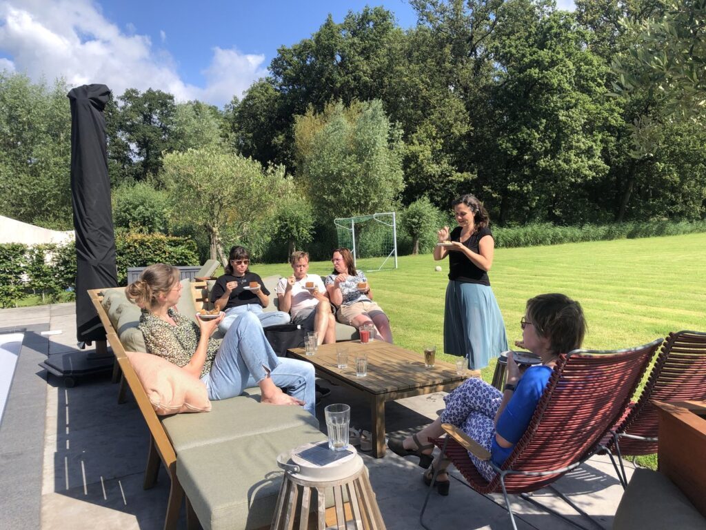 Deelnemers in gesprek op het terras in de zon