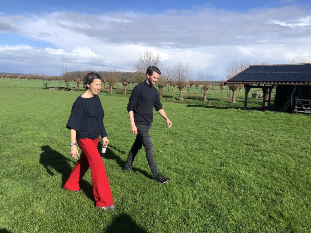 Twee mensen lopen in gesprek over het veld